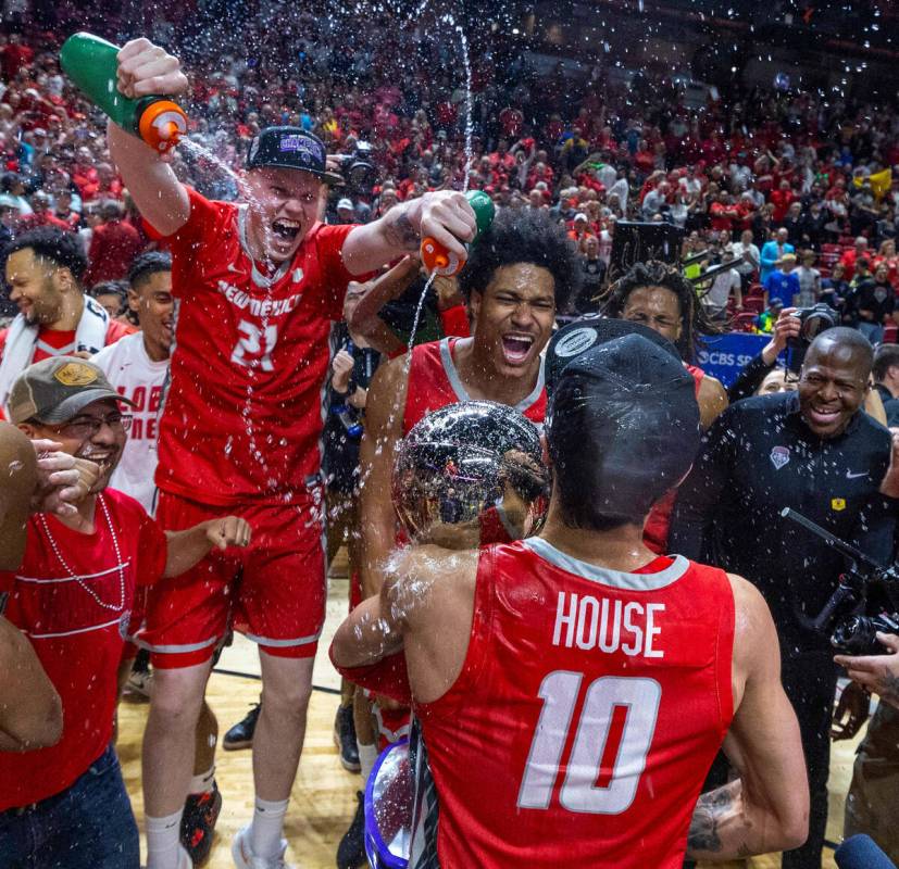 New Mexico Lobos center Sebastian Forsling (21) douses water on teammates guard Jamal Mashburn ...