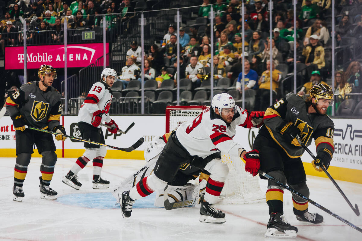 Golden Knights defenseman Noah Hanifin (15) and New Jersey Devils right wing Timo Meier (28) fi ...
