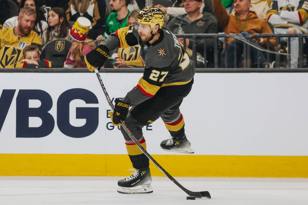 Golden Knights defenseman Shea Theodore (27) hits the puck to a teammate during an NHL game bet ...