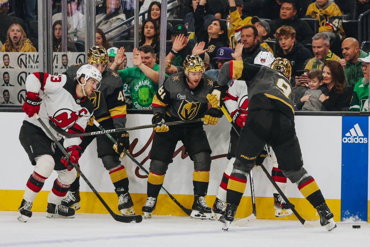 Golden Knights center Jack Eichel (9) tries to free the puck from a group of players during an ...