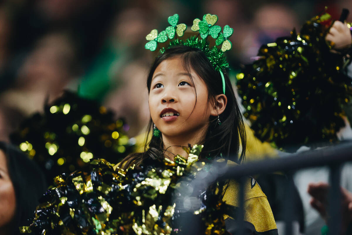 A young Golden Knights fan dressed up for St. Patrick’s Day cheers for her team during a ...
