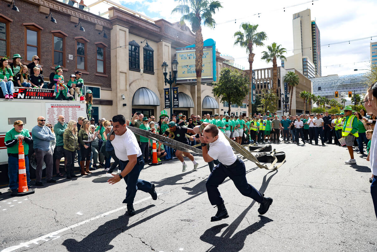 Firefighters compete in a dragging tires race at a St. Patrick’s Day event hosted by the Prof ...