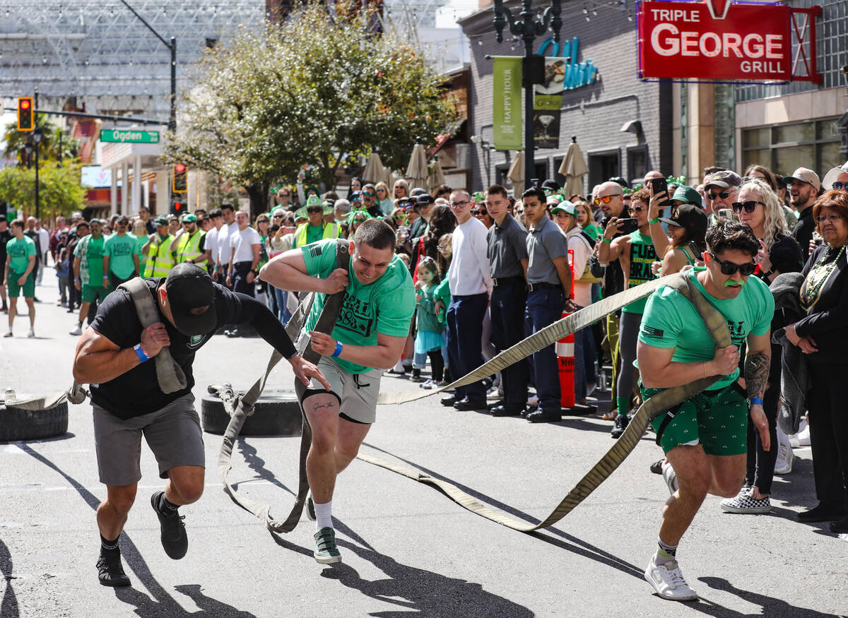 Firefighters compete in a dragging tires race at a St. Patrick’s Day event hosted by the ...