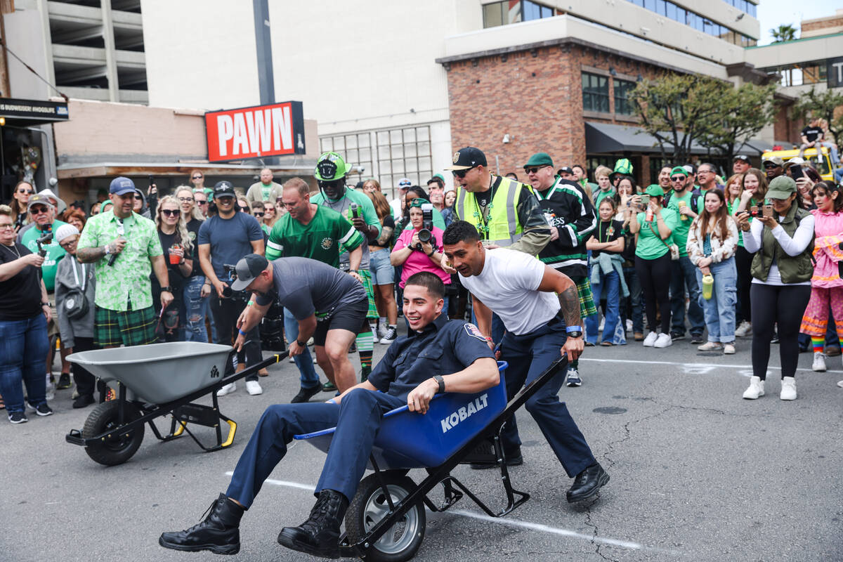 Firefighters compete in a wheel barrel race at a St. Patrick’s Day event hosted by the P ...