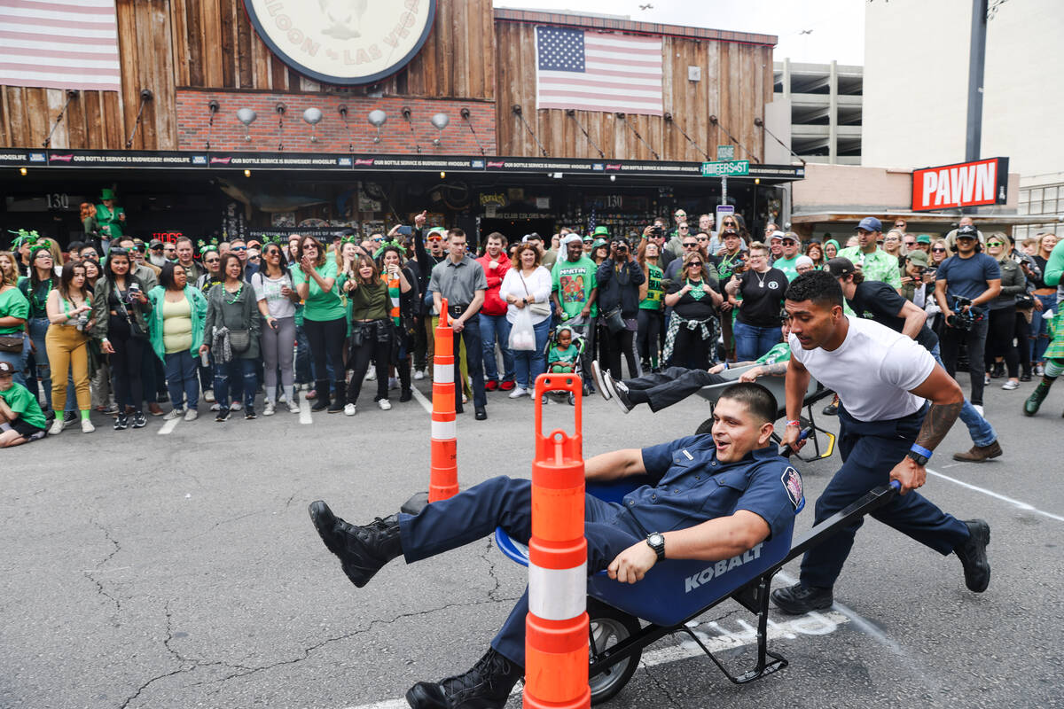 Firefighters compete in a wheel barrel race at a St. Patrick’s Day event hosted by the P ...