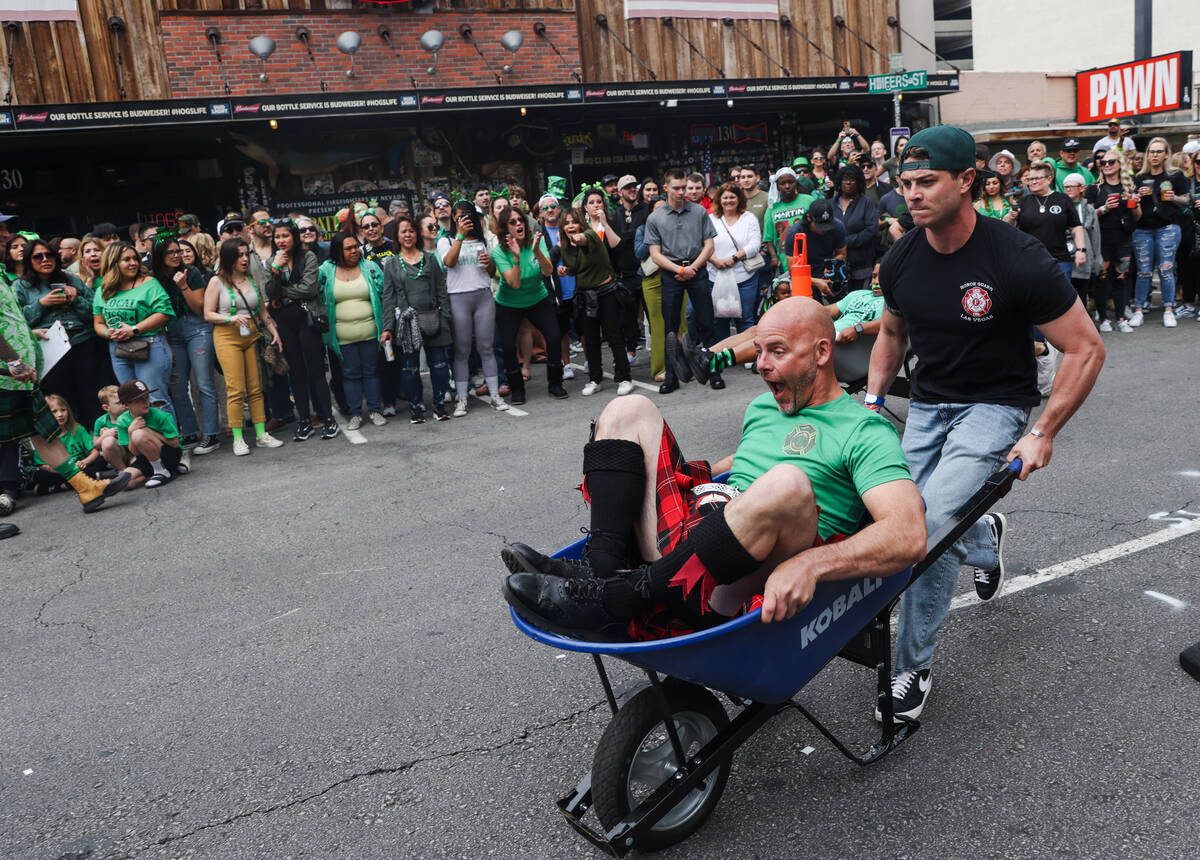 Firefighters compete in a wheel barrel race at a St. Patrick’s Day event hosted by the P ...