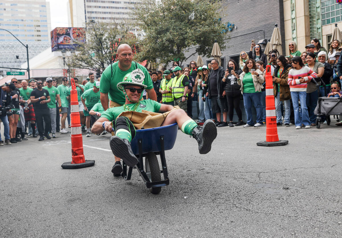 Firefighters compete in a wheel barrel race at a St. Patrick’s Day event hosted by the P ...