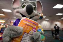 An employee dressed as Chuck E. Cheese holds a flyer advertising new memberships at a location ...