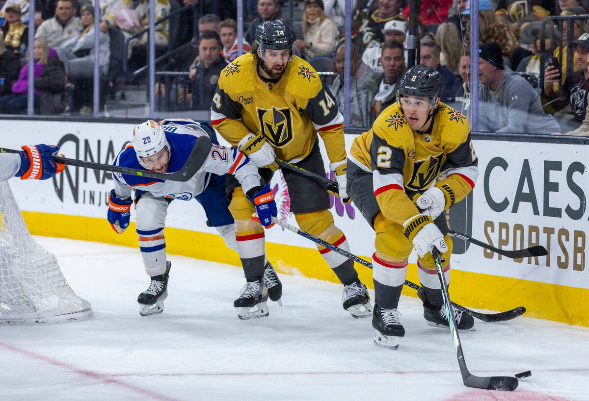 Golden Knights defenseman Zach Whitecloud (2) looks to pass after teammate defenseman Nicolas H ...