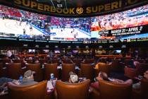 Guests watch on the big screens the first day of the NCAA basketball tournament at the Sports B ...