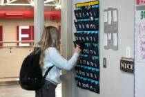 A ninth grader places her cellphone in to a phone holder as she enters class at Delta High Scho ...