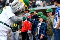 A young Oakland Athletics fan slaps hands with mascot Stomper during a Major League Baseball sh ...