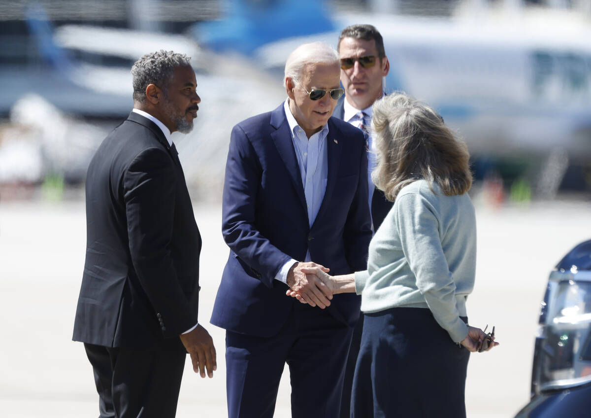 President Joe Biden is greeted by Rep. Steven Horsford, left, and Congresswoman Dina Titus afte ...