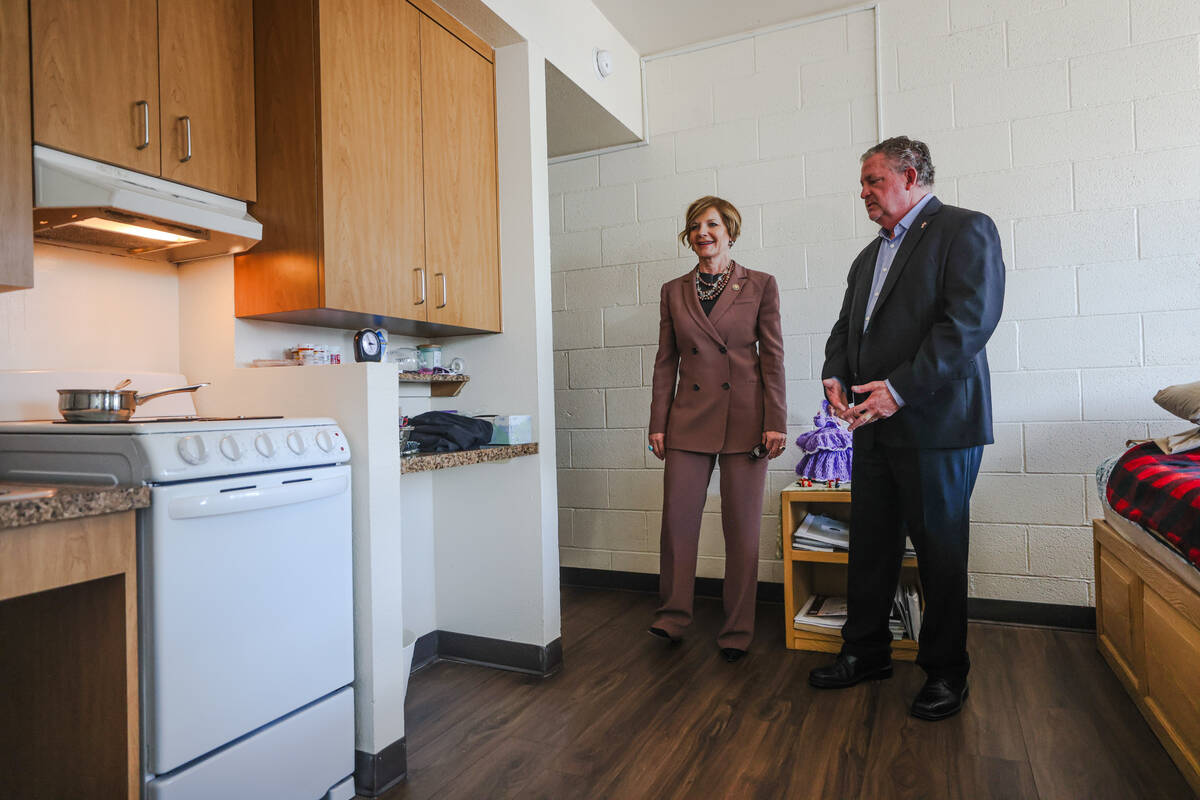 Rep. Susie Lee, D-Nev., left, and CEO Tom Roberts, right, take a tour of a bedroom at Catholic ...