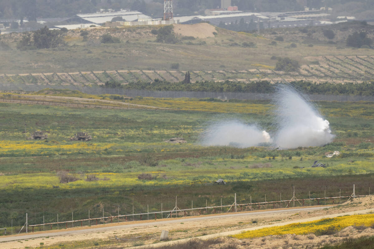 An Israeli tank, center, moves near the Israeli-Gaza border as seen from southern Israel, Monda ...