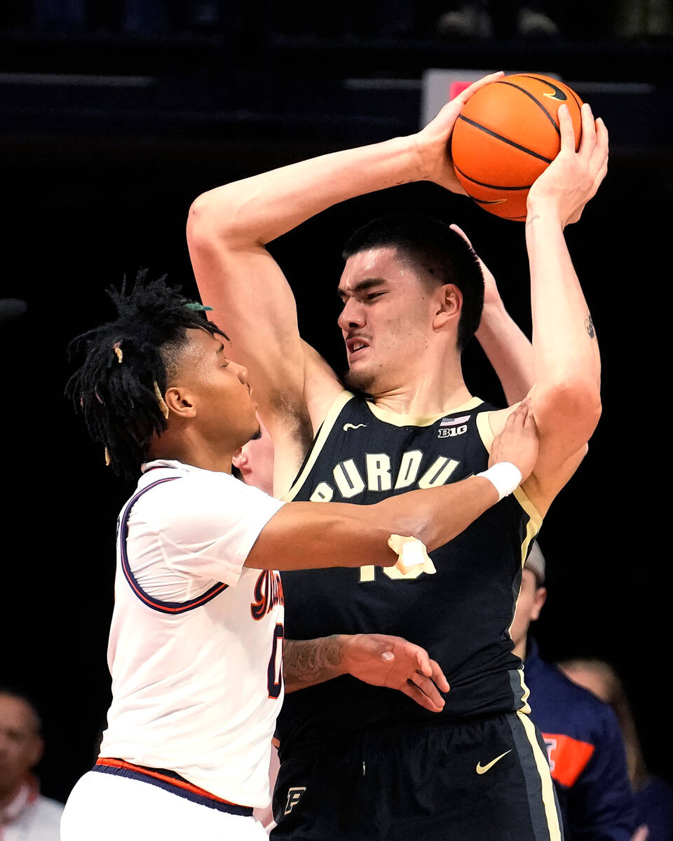 Illinois' Terrence Shannon Jr. fouls Purdue's Zach Edey during the first half of an NCAA colleg ...