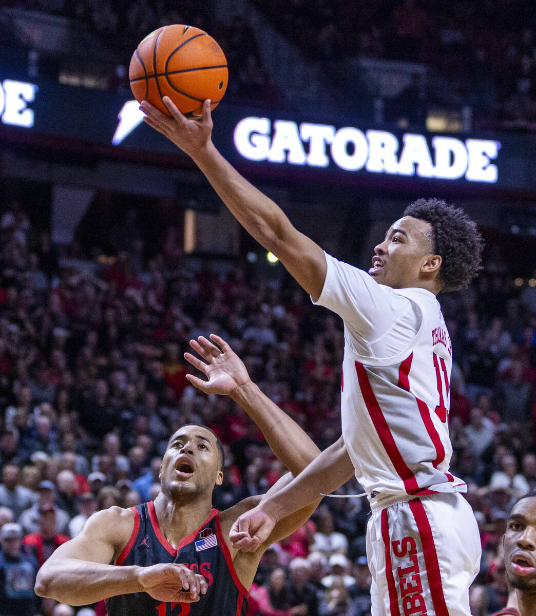 UNLV Rebels guard Dedan Thomas Jr. (11) extends to score past San Diego State Aztecs forward Ja ...