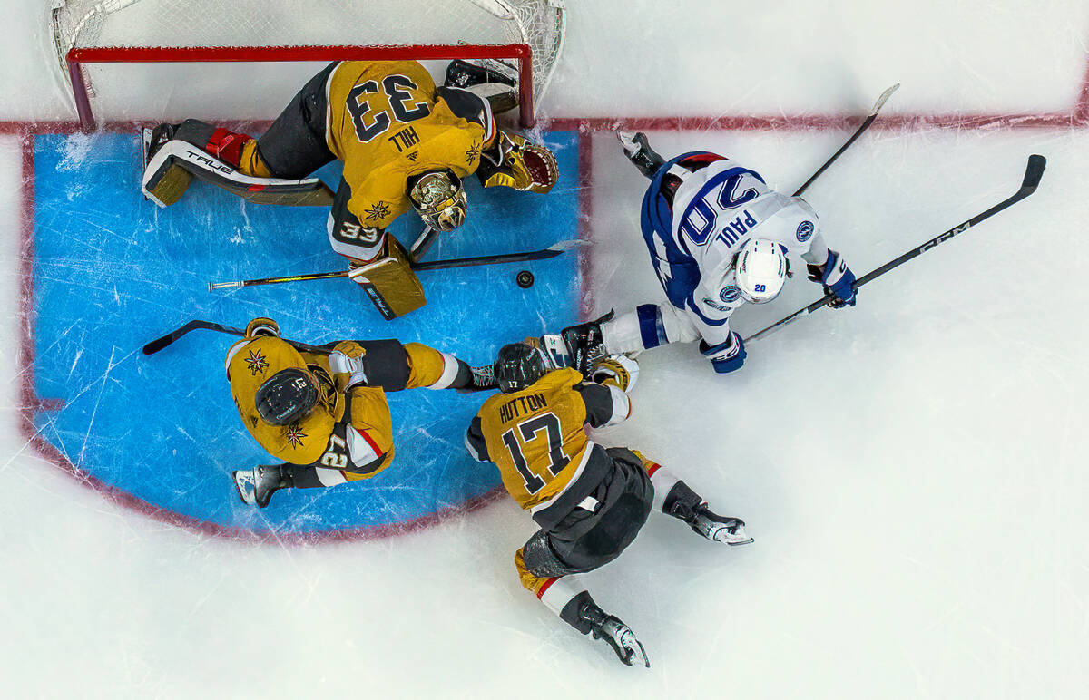 Golden Knights goaltender Adin Hill (33) looks to smother a shot by Tampa Bay Lightning left wi ...