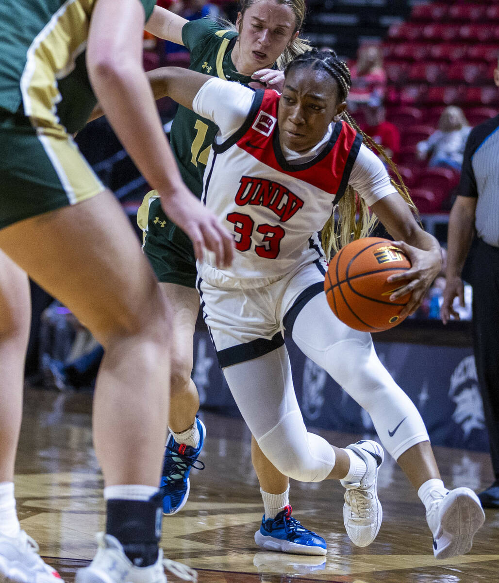 UNLV Lady Rebels guard Amarachi Kimpson (33) weaves through traffic past Colorado State Rams gu ...