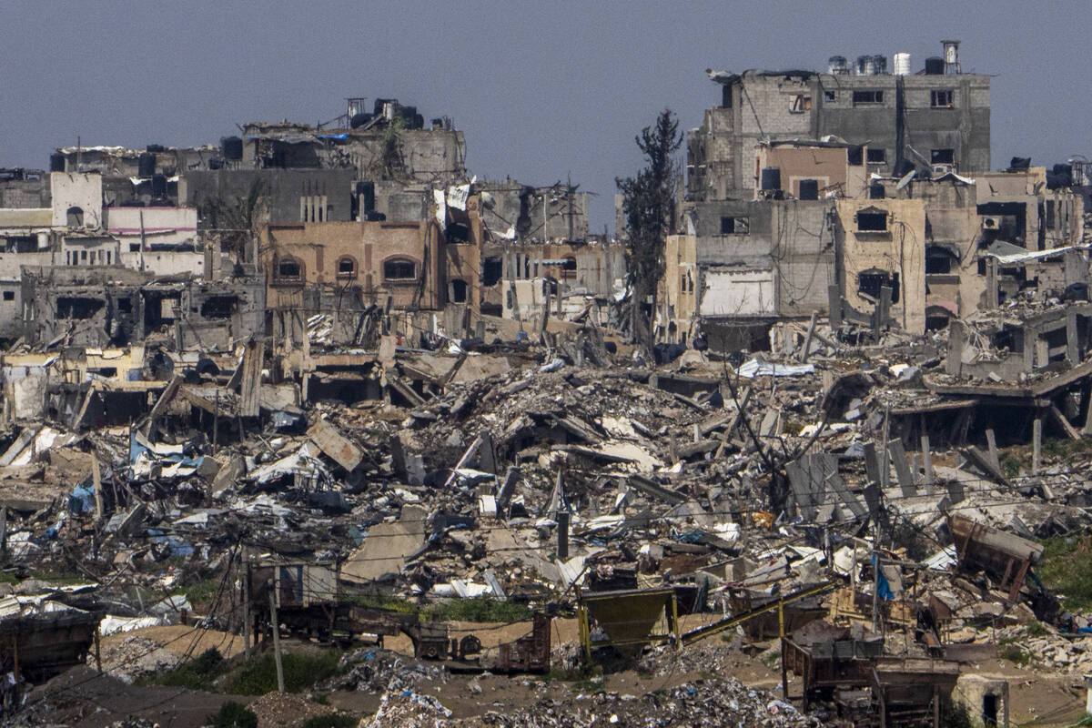 Destroyed buildings stand inside Gaza Strip, as seen from southern Israel, Tuesday, March 19, 2 ...