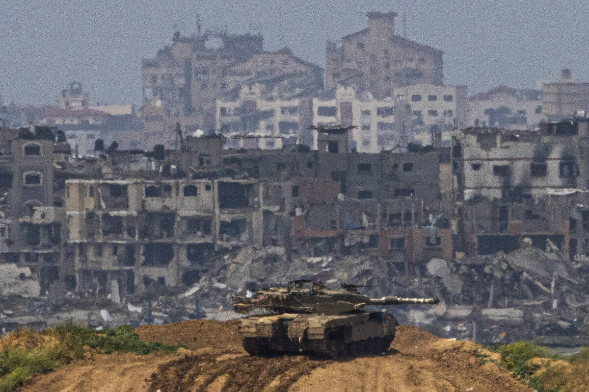 Israeli soldiers on a tank on a position on the border with Gaza Strip, in southern Israel, Tue ...