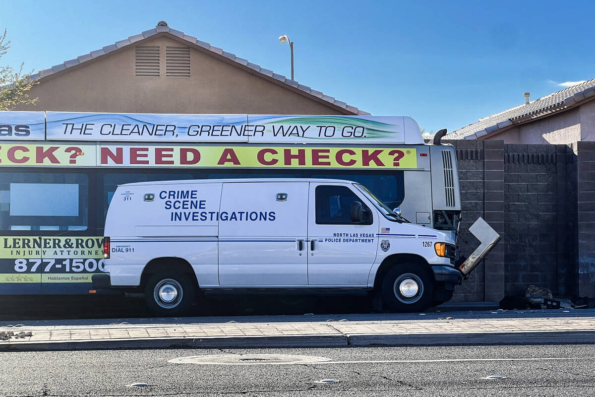 A North Las Vegas Police Department crime scene investigation van is parked next to an RTC bus ...