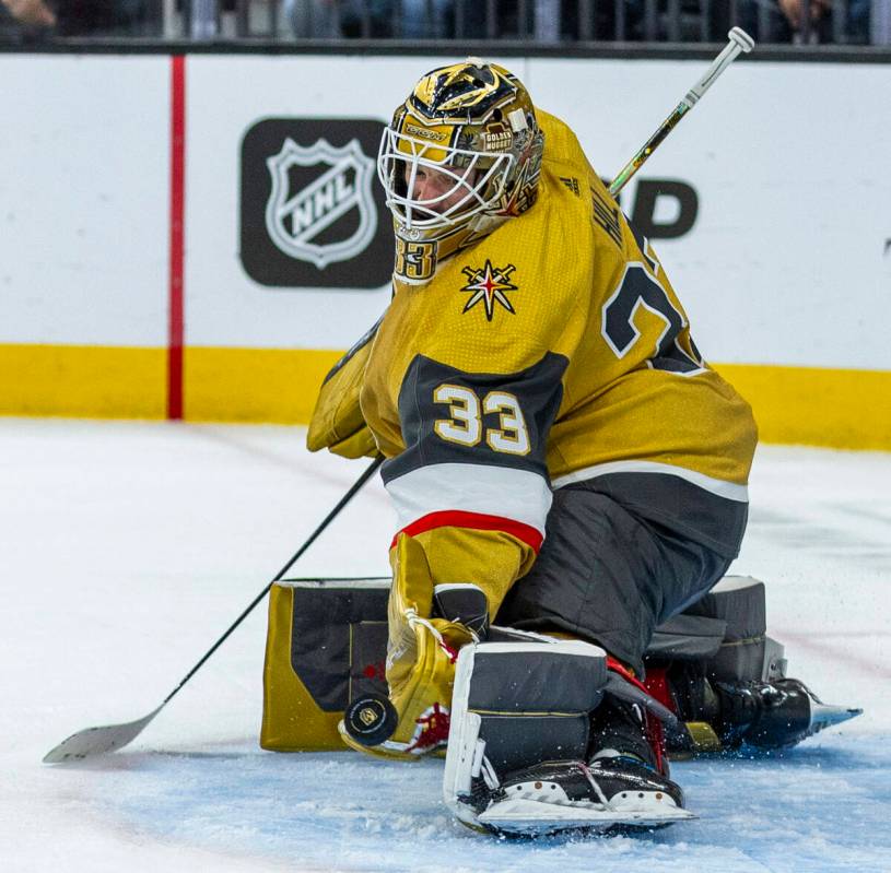 Golden Knights goaltender Adin Hill (33) readies to snag a puck shot by the Tampa Bay Lightning ...