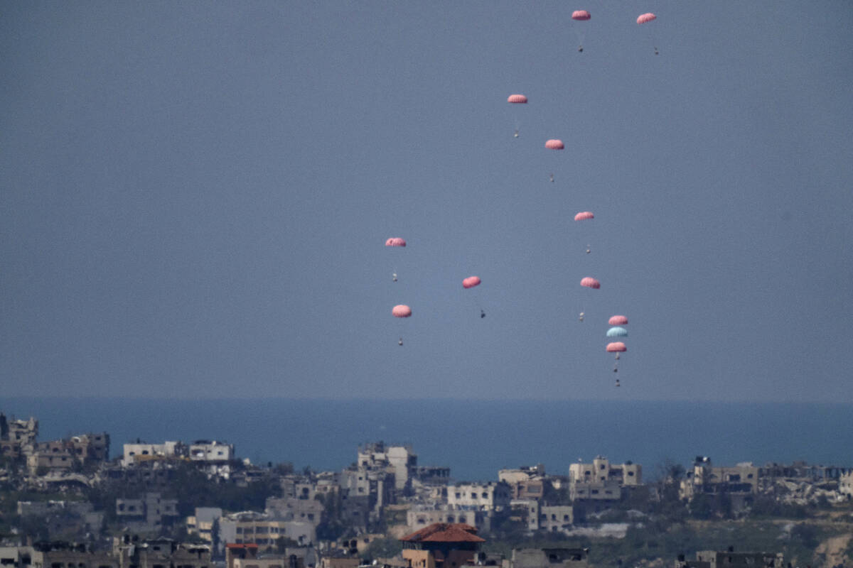 Parachutes drop supplies into the northern Gaza Strip, as seen from southern Israel, Wednesday, ...