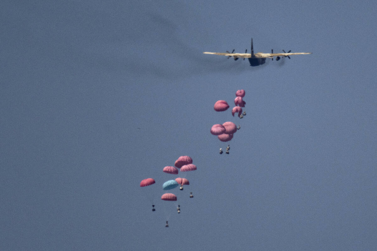 An aircraft airdrops humanitarian aid over northern Gaza Strip, as seen from southern Israel, W ...