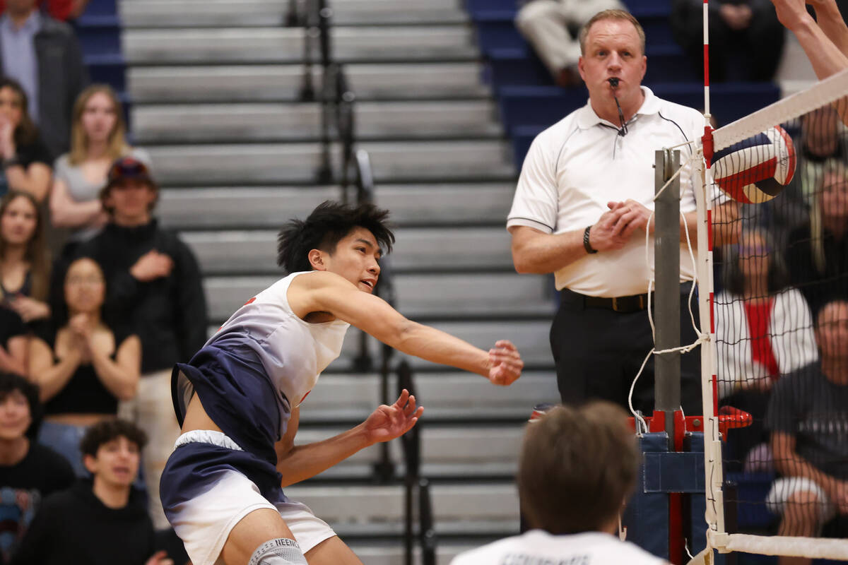 Coronado outside hitter Aiden Camacho spikes past the net for a point during a boys high school ...
