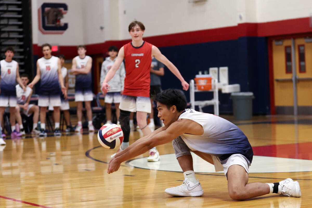 Coronado outside hitter Aiden Camacho lunges to bump during a boys high school volleyball match ...