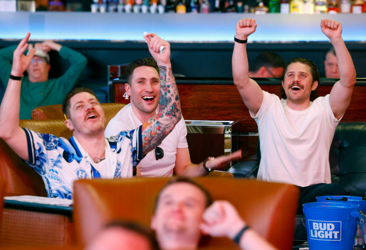 Ian Bullock, left, Andrew Massey and Ben Vietze, right, all of California, react on a play as t ...