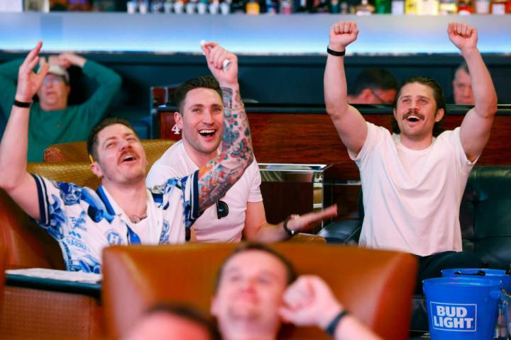 Ian Bullock, left, Andrew Massey and Ben Vietze, right, all of California, react on a play as t ...