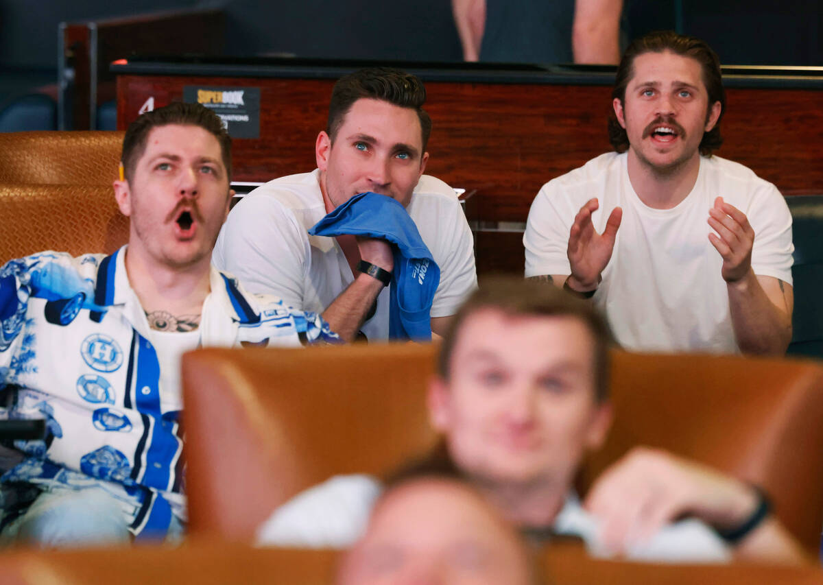 Ian Bullock, left, Andrew Massey and Ben Vietze, right, all of California, react on a play as t ...