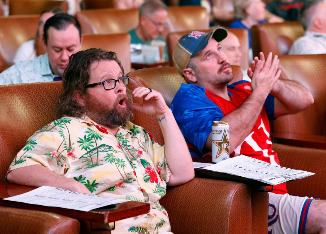 Frank Hunt, left, and Chais Griffith, all of Arizona, react on a play as they watch on the big ...