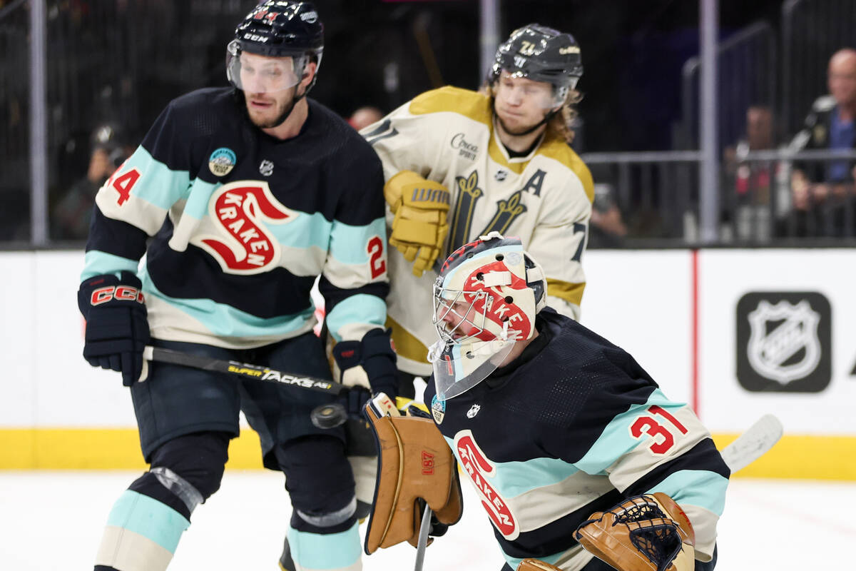 Kraken goaltender Philipp Grubauer (31) prepares to save while defenseman Jamie Oleksiak (24) g ...