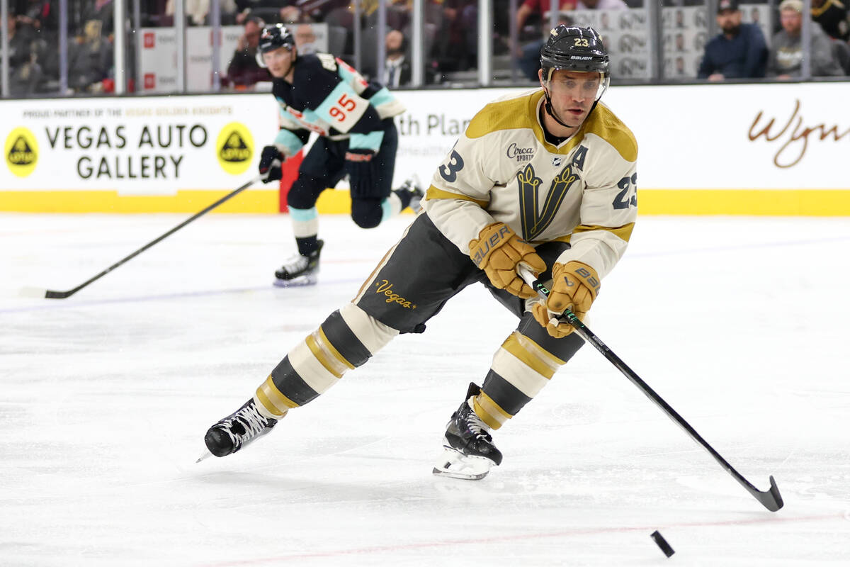 Golden Knights defenseman Alec Martinez (23) skates for the puck while Kraken left wing Andre B ...