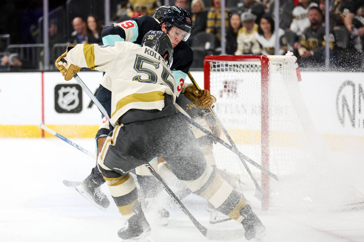 Kraken defenseman Ryker Evans (39) attempts to thwart Golden Knights right wing Keegan Kolesar ...