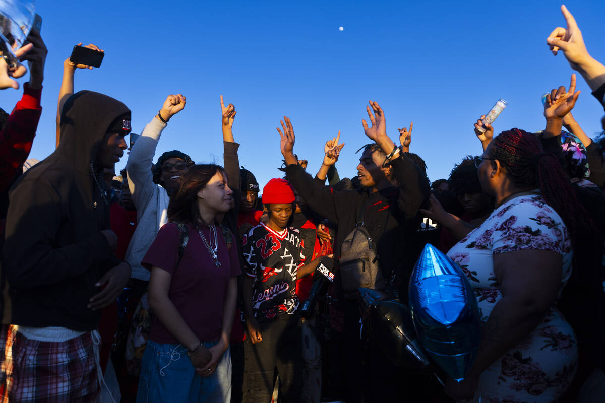 Friends and family react during a vigil in memory of Devin Heath, 17, who died after being hit ...