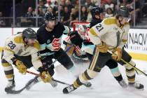 Golden Knights left wing William Carrier (28) tangles with Kraken defenseman Justin Schultz (4) ...