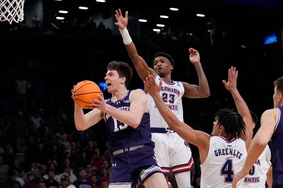 Northwestern's Brooks Barnhizer (13) drives past Florida Atlantic's Brandon Weatherspoon (23) a ...