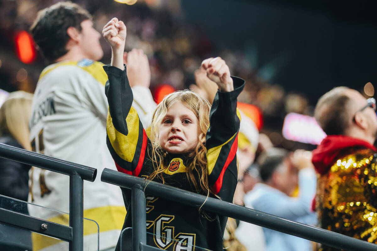 A young Golden Knights fan celebrates a goal during an NHL hockey game between the Golden Knigh ...