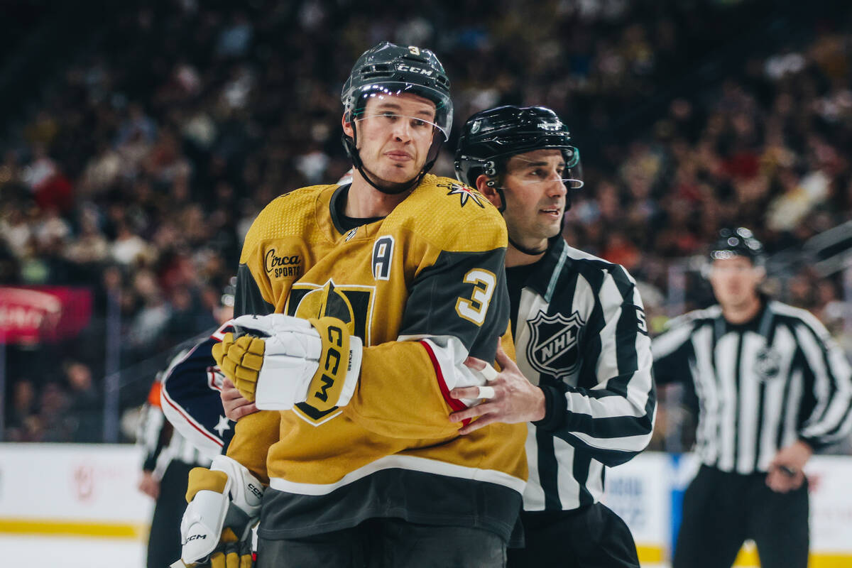 A referee moves Golden Knights defenseman Brayden McNabb (3) after he shoved an opponent to the ...
