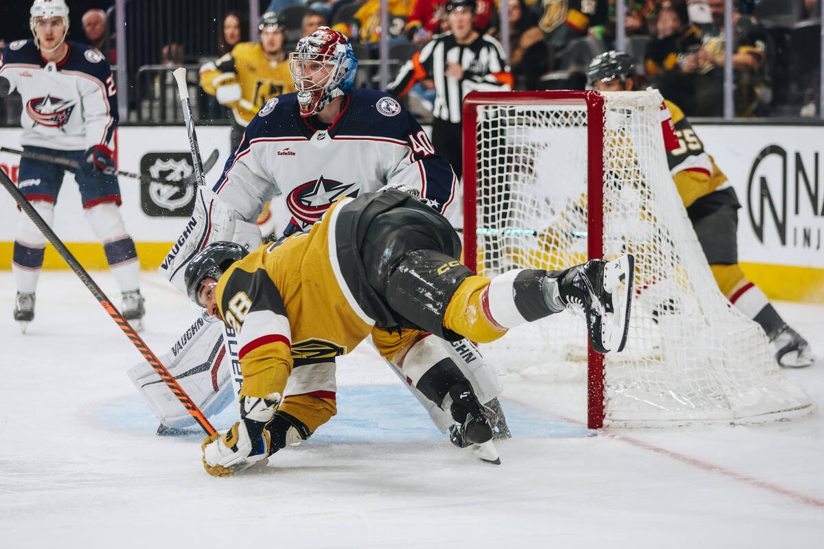 Golden Knights left wing William Carrier (28) falls onto Columbus Blue Jackets goaltender Danii ...