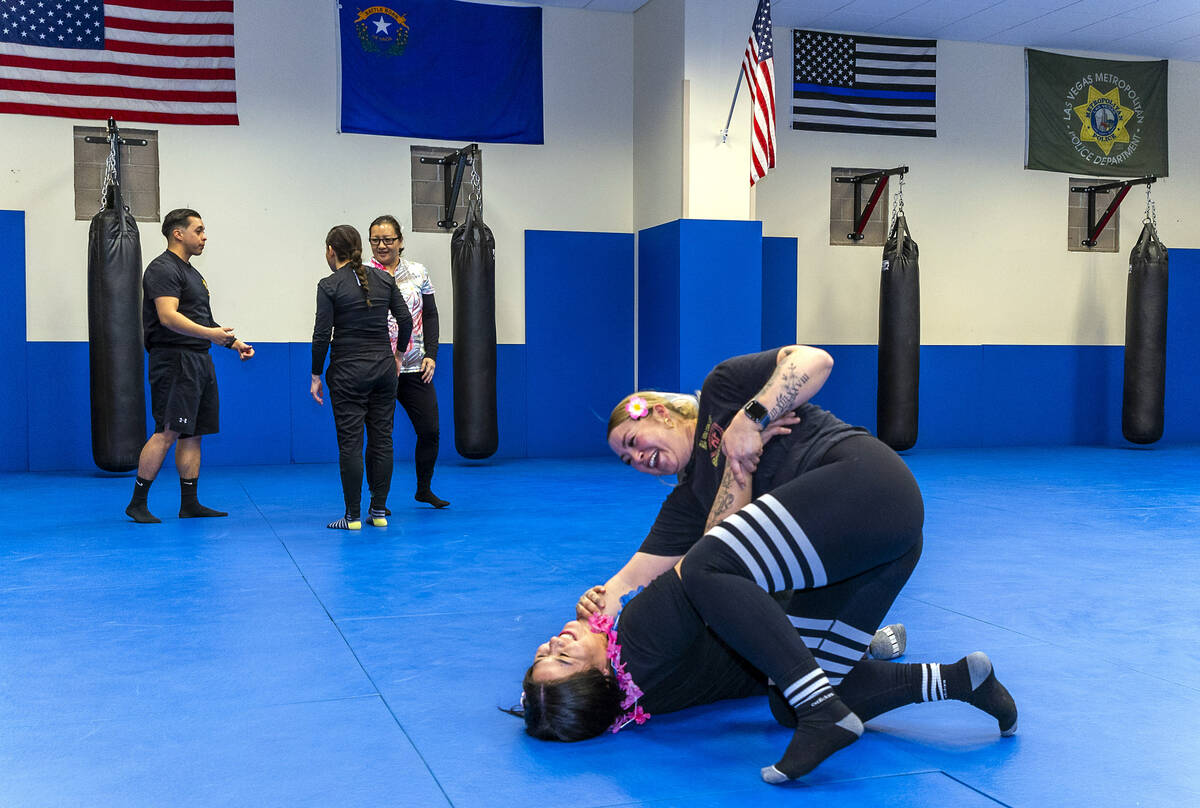 Attendee Serena Moran, top, does a sweep takedown maneuver on parter Claudia Martinez as the tw ...