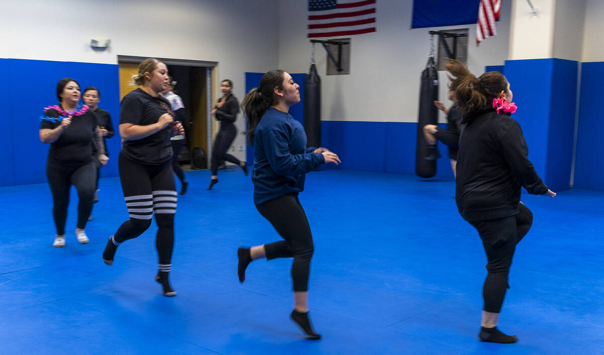Attendees do warm up exercises before learning defensive tactics with the Metro recruiting depa ...
