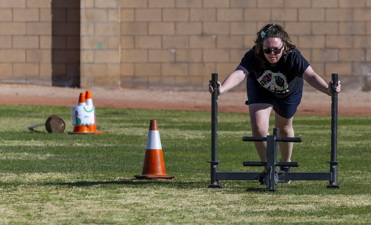 Attendee Elisa Gow pushes a sled down the field as women participate in an outside circuit wor ...