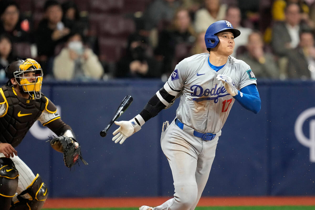 Los Angeles Dodgers designated hitter Shohei Ohtani, right, heads to first as he grounds out wh ...