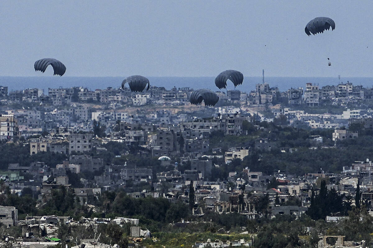 Parachutes drop supplies into the northern Gaza Strip, as seen from southern Israel, Sunday, Ma ...