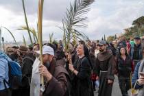 Christians walk in the Palm Sunday procession on the Mount of Olives in east Jerusalem, Sunday, ...